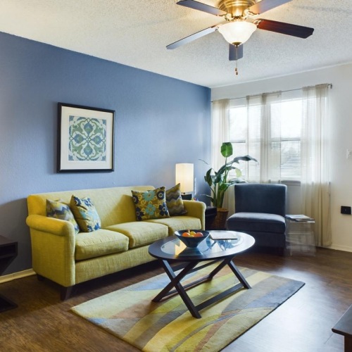 a living room with a fan and couches