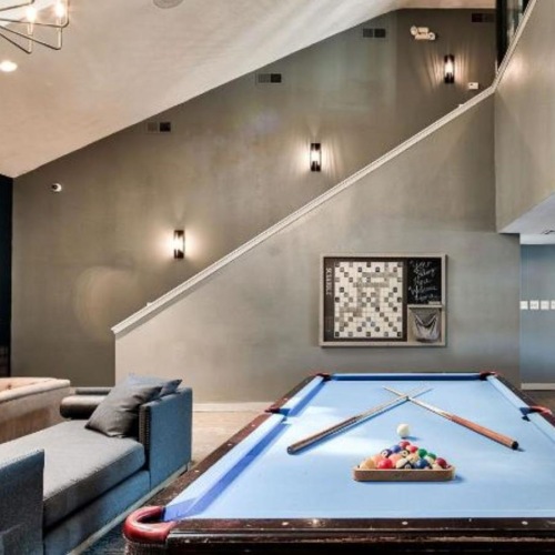 a room with a pool table and chairs