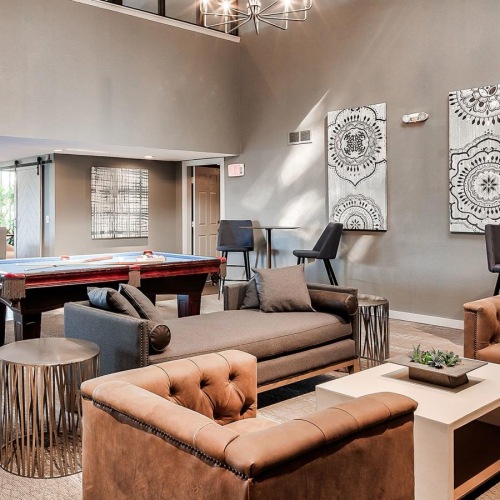 a room with a pool table and chairs